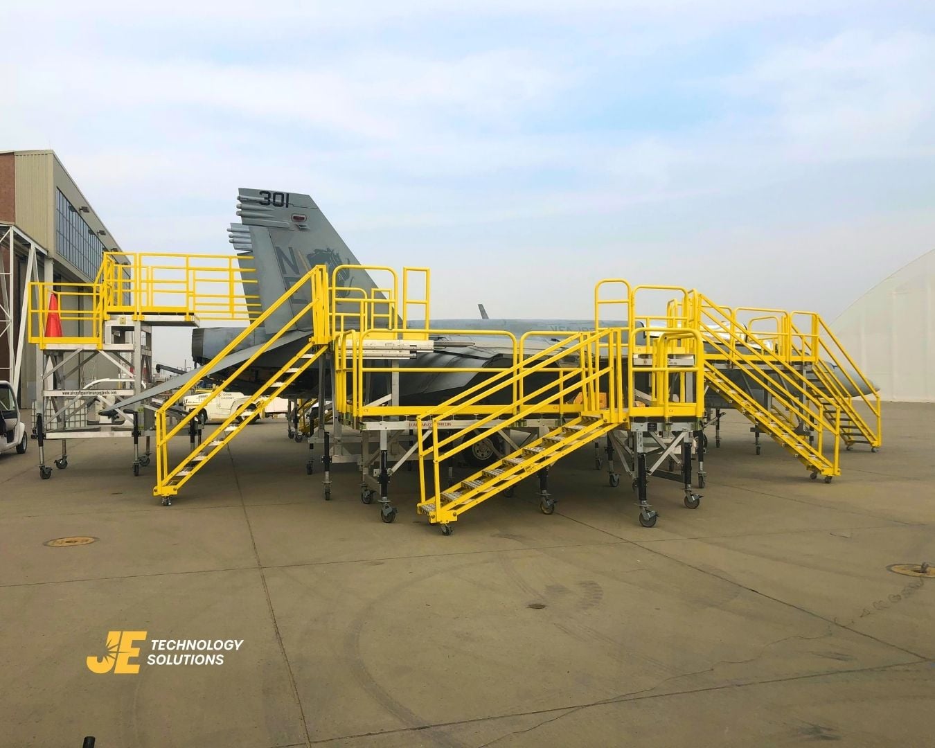 An F-18 maintenance access stand with integrated guardrails serving an elevated service zone