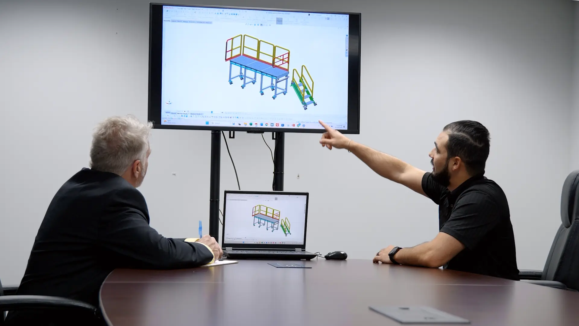 Two JE engineers reviewing a platform design on screen