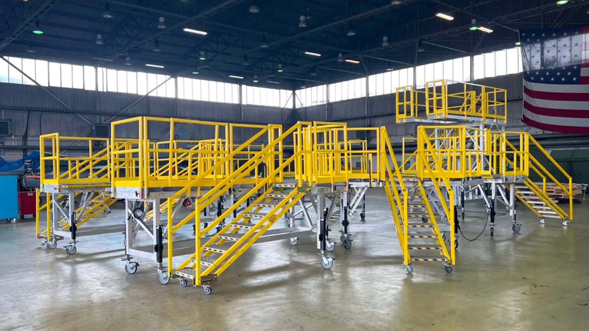 A JE aircraft maintenance stand positioned against an airframe