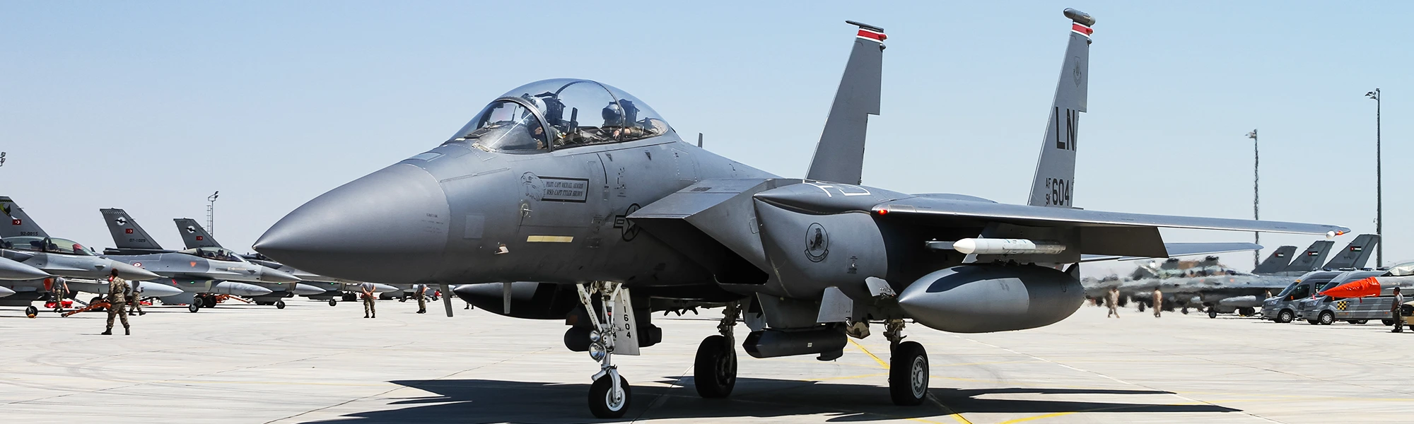 F-15E Strike Eagle on a flight line with other fighters behind it