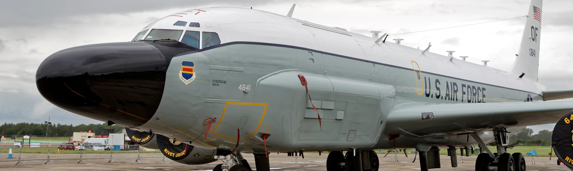 A JE wing maintenance stand positioned against a large military airframe